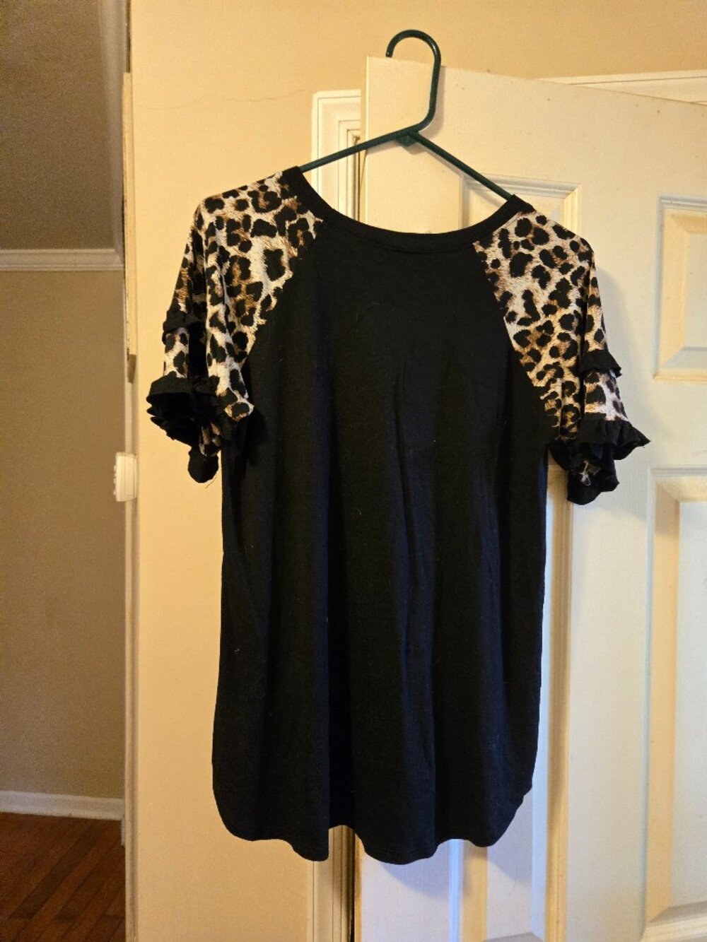 Celeste M black top with ruffled leopard sleeves, cute dress up or down piece